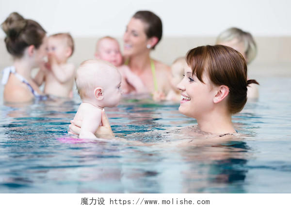 婴儿游泳班的妈妈和他们的孩子游泳教练亲子游泳婴幼儿游泳